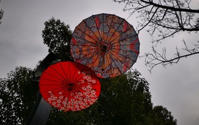 Два разноцветных японских зонтика на фоне неба