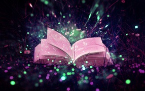 Открытая магическая книга лежит в траве