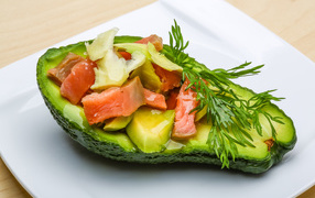 Avocado with red fish salad on white plate