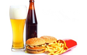Beer on a white plate with hamburgers and french fries.