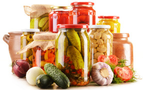 Консервация в банках на белом фоне с овощами