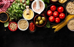 Cereals on the table with greens, tomatoes, olives and spaghetti