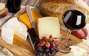 Cheese on the table with grapes and wine.