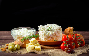 Cottage cheese on the table with cheese, bread and tomatoes