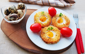 Croutons with scrambled eggs and tomatoes on the table with quail eggs