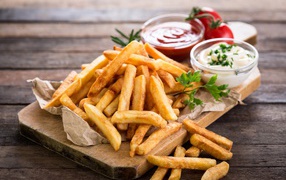 French fries on a board with sauce