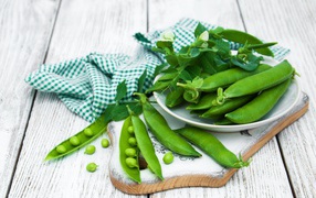 Fresh green peas on a table with a towel