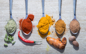 Молотые специи в ложках на столе 