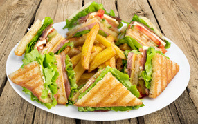 Сэндвичи с ветчиной на тарелке с картофелем фри 