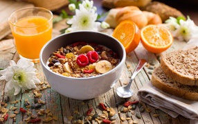 Мюсли в миске с молоком на завтрак с соком и апельсинами 