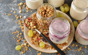 Muesli in a jar on a table with yogurt