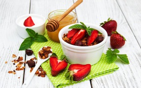 Muesli with strawberries and honey on the table
