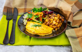 Omelet on a plate with salad and vegetables