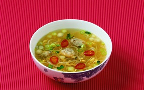 Plate of seafood soup on a red background