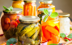 Консервация в стеклянных банках на столе со специями