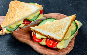 Sandwich with cheese, tomatoes and cucumbers on the table