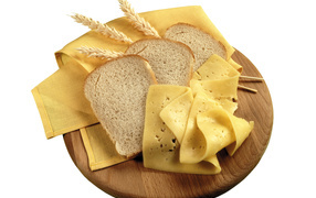 Куски хлеба на разделочной доске с сыром 