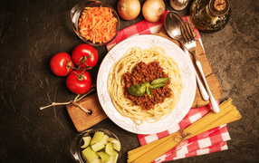Spaghetti with minced meat on the table with vegetables