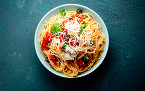 Spaghetti with tomatoes, cheese and basil on the table
