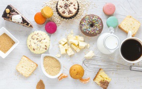 Сладости на столе с молоком и чашкой кофе