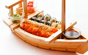Wooden ship with sushi, sauce and ginger