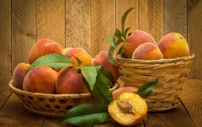 Аппетитные сочные спелые персики в корзинках на столе