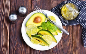Авокадо и лимон нарезанный кусочками на тарелке
