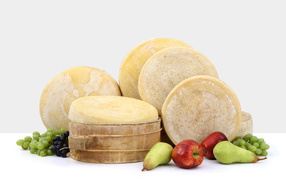 Cheese on a table with pears, apples and grapes