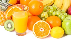 Свежие сочные фрукты на белом фоне со стаканом сока