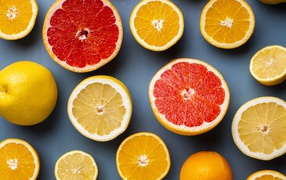 Лимоны, грепфрукты и апельсины на сером фоне
