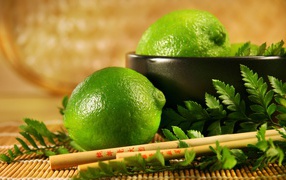 Limes on the table with chopsticks and leaves