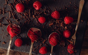 Raspberries on a table with chocolate chips