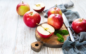 Ripe red apples on a cutting board with a knife
