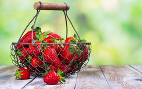 Ripe red strawberries in a basket on a table
