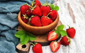 Ripe strawberries on a table in a wooden bowl