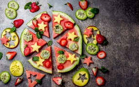 Кусочки арбуза с фруктами на сером фоне