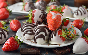 Strawberries in chocolate and sugar on a white plate