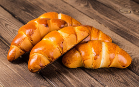 Appetizing ruddy croissants on a wooden table