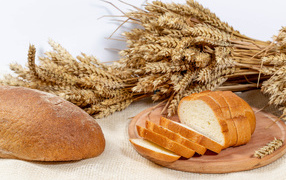 Fresh fragrant bread on the table with ears of wheat