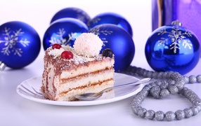 Кусок торта на тарелке на столе с елочными украшениями