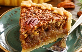 Кусок пирога с орехами на тарелке с вилкой