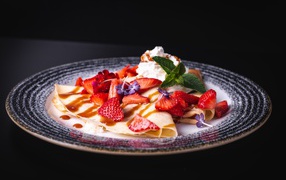 Аппетитные тонкие блинчики с клубникой на черном фоне