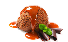 Ball of chocolate ice cream with caramel on a white background