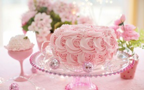 Красивый розовый торт на столе с цветами