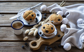 Кексы с черникой на столе с колосьями и кофе