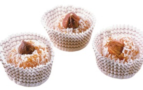 Конфеты с кокосовой стружкой и орехами на белом фоне