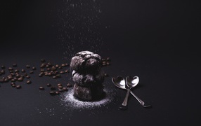 Chocolate cookies with icing sugar on a black background with coffee beans