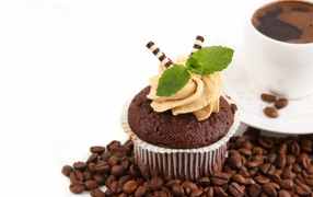 Chocolate muffin with cream on a coffee table and coffee beans