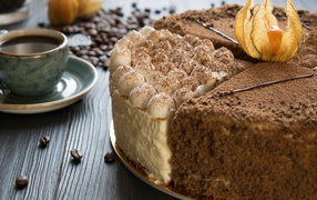 Вкусный торт с кремом и физалисом на столе с кофе