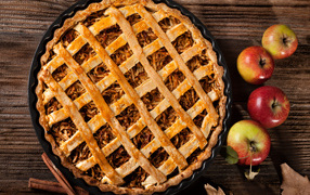 Вкусный горячий пирог на столе с яблоками 
